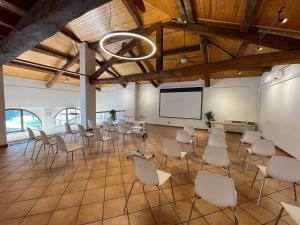 Habitación grande con sillas y pantalla de proyección en Hotel Santo Stefano, en Campagnola Emilia