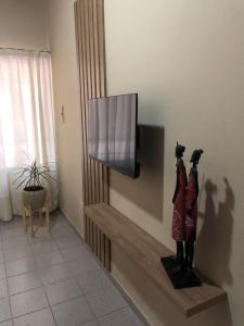 sala de estar con TV de pantalla plana en la pared en Apartamentos María en San Rafael