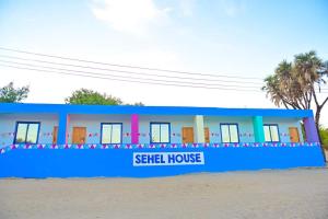 a blue building on the beach with a sign that reads sell house at Sehel Nubian House in Naj‘ al Maḩaţţah