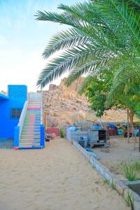 a playground with a slide and a palm tree at Sehel Nubian House in Naj‘ al Maḩaţţah