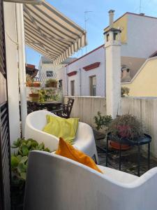 eine Terrasse mit einem Sofa und Stühlen auf dem Balkon in der Unterkunft Apulia Mola in Mola di Bari