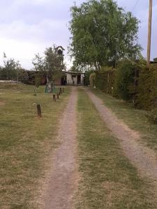 un camino de tierra que conduce a un patio con parque infantil en RUKAFUCHA en Mendoza