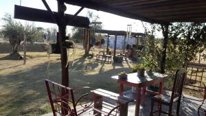 un patio con mesa, sillas y sombrilla en RUKAFUCHA en Mendoza