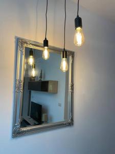 un espejo con luces frente a una pared en New Two bedroom flat Kamila on a dwell, en Sliema