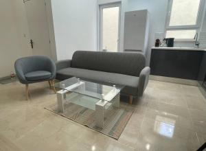 - un salon avec un canapé et une table basse en verre dans l'établissement New Two bedroom flat Kamila on a dwell, à Sliema