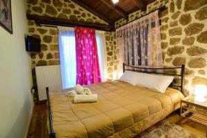 a bedroom with a bed with a teddy bear on it at Filanthi in Kato Trikala Korinthias