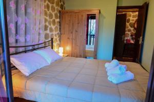 a bedroom with a large bed with towels on it at Filanthi in Kato Trikala Korinthias