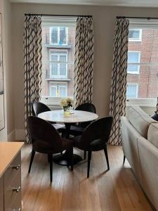 倫敦的住宿－One bedroom flat in Chelsea，客厅配有桌椅和沙发