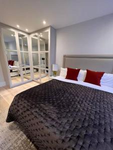 - une chambre avec un grand lit et des oreillers rouges dans l'établissement One bedroom flat in Chelsea, à Londres
