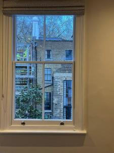 une fenêtre blanche avec vue sur un bâtiment dans l'établissement One bedroom flat in Chelsea, à Londres