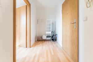 eine offene Tür zu einem Zimmer mit Holzboden in der Unterkunft Helles modernes Studio m. Küche, Nahe Uni in Cottbus