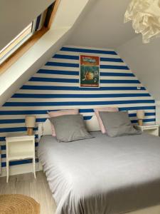 a bedroom with a blue and white striped wall at TY SEA in Morgat