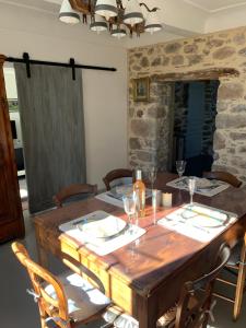 mesa de comedor con sillas y pared de piedra en Maison de village authentique, en Octon