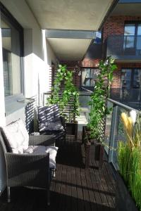 een patio met stoelen en planten op een balkon bij PORT19 in Wrocław