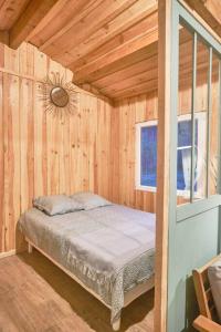 um quarto com uma cama num quarto de madeira em Gîte familial en pleine nature- Domaine Temali em Labouheyre