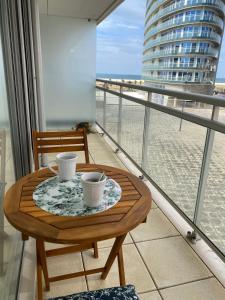 a table with two cups on top of a balcony at Chez Ocean Plaza in Figueira da Foz