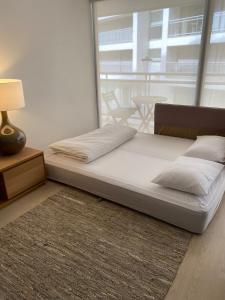 a bed in a room with a large window at Chez Ocean Plaza in Figueira da Foz