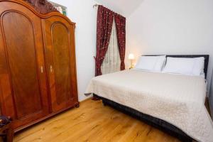 1 dormitorio con 1 cama y armario de madera en Apartment Oskar, en Supetar