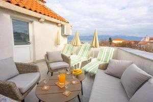 un patio con sedie e un tavolo sul balcone. di Apartment Oskar a Supetar (San Pietro di Brazza)