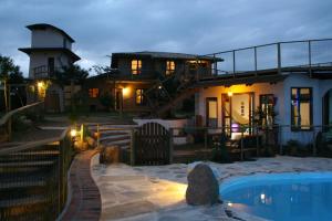 a house with a swimming pool in front of it at Pousada Gopak in Praia do Rosa