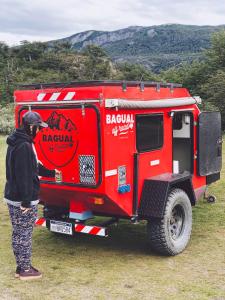 a person standing in front of a red truck at BAGUAL TRAILER in Ushuaia