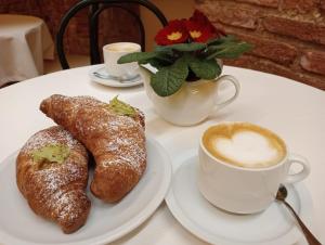 a table with two pastries and a cup of coffee at Meublè Evoè in Montepulciano