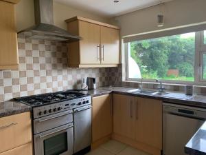 a kitchen with a stove and a sink and a window at Dove House in Killala