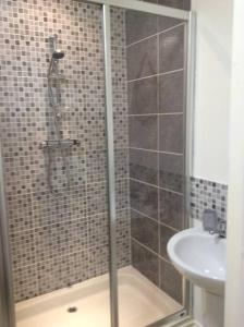 a shower with a glass door next to a sink at Lesbury Lodge - (a 'bijou residence') with hot tub in Alnwick +9 photos