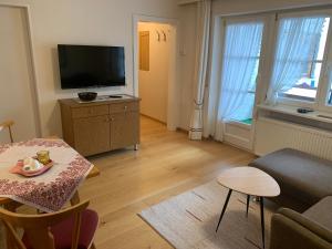 uma sala de estar com uma televisão e uma mesa em Ferienhaus Kessler em Riezlern