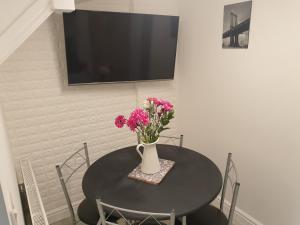 uma mesa preta com um vaso de flores em Marlow's Emerald 3 Bedroom House em Marlow