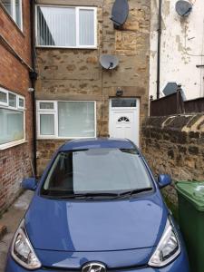 um carro azul estacionado em frente a um edifício em Birtley's Diamond 3 bed Apt sleeps 6 Guests em Birtley