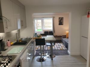 a kitchen with a table and a living room at Marlow's Emerald 3 Bedroom House in Marlow