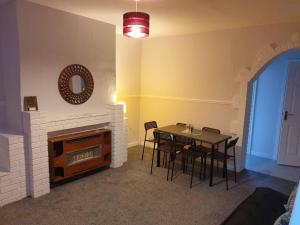 a dining room with a table and a fireplace at Chester le Street Amethyst 3 Bedroom House in Chester-le-Street