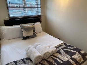 łóżko z ręcznikami i oknem w obiekcie Washington's Hidden Gem Amethyst 3 Bedroom House s w mieście Washington