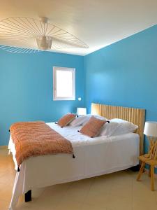 a blue bedroom with a large white bed with blue walls at Villa U Tramontu in Granace