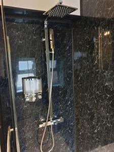 a bathroom with a shower with a black marble wall at South Shield's Hidden Gem Garnet 3 Bedroom Apartme in South Shields