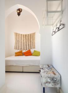 a white room with a bed with colorful pillows at Dar Said in Asilah