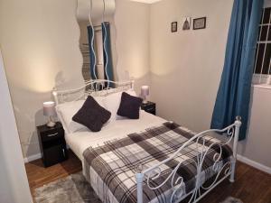 a bedroom with a bed and blue curtains at Washingtons Emerald 2 Bed Exec Apt in Washington