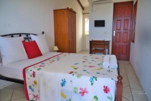 a bedroom with a bed and a red door at Location Bellevue - Pomme Cannelle in Saint-Louis