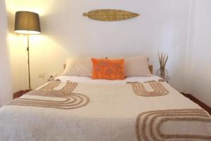 a bedroom with a large bed with orange pillows at TheMalkohaVilla in Umsning
