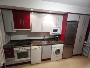 a kitchen with white cabinets and a sink and a dishwasher at Cómoda vivienda en Huesca in Huesca