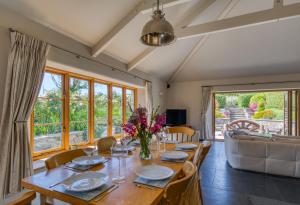 een eetkamer met een tafel, stoelen en een bank bij Putsborough Manor 3 Self Catering Cottages with Beach a short walk, dog friendly all year, On site Tennis, Play Area, Paddock, Spa baths, BBQ, Private Gardens, Superfast WIFI in Croyde