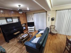 sala de estar con sofá y piano en Cómoda vivienda en Huesca, en Huesca