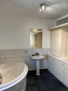 a white bathroom with a tub and a sink at Park cottage High Crompton in Shaw