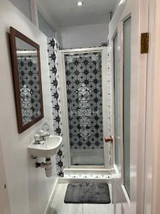 a small bathroom with a sink and a shower at Park cottage High Crompton in Shaw