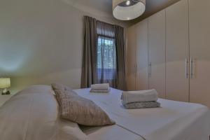uma grande cama branca num quarto com uma janela em Janamari em Zadar