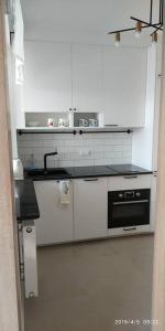 uma cozinha branca com um lavatório e um fogão em New cozy apartment near the center, Mokotów em Varsóvia