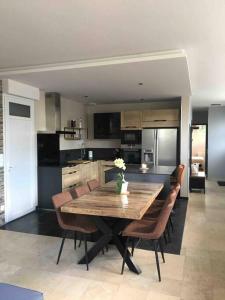 cocina grande con mesa de madera y sillas en Gîte D Day en Carentan