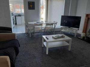 a living room with a couch and a table and a tv at South Shield's Hidden Gem Amethyst 3 Bedroom House in South Shields