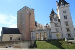 un château avec deux tours et une tour d'horloge dans l'établissement Quartier Historique du Château bel appt meublé, à Pau